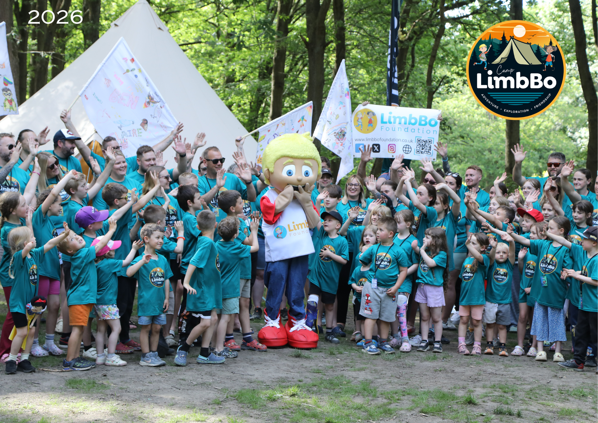a group of children all in green t shirts surrounding the limbBo mascot, big tommy